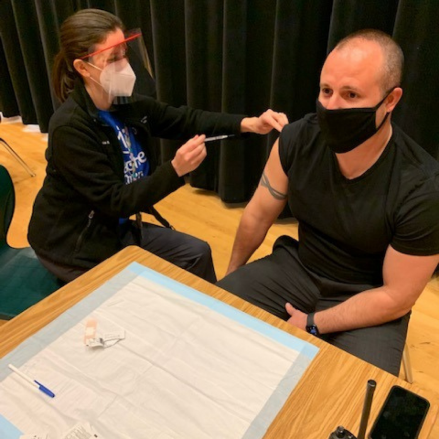 Mr. Phillips receives his first vaccine dose in the auditorium. 