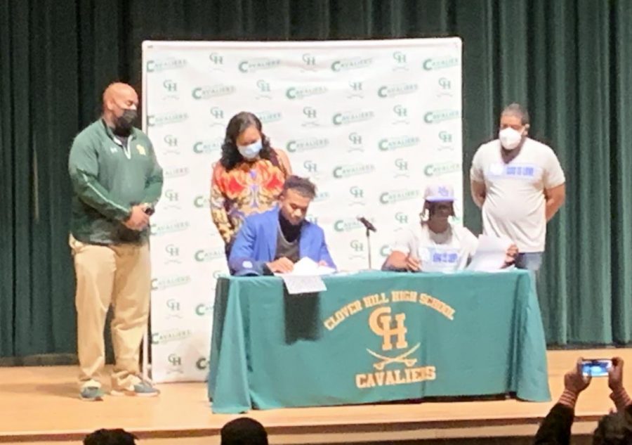 Bryson Jennings and Abe Uqdah signing their official letters of intent before their Clover Hill teammates and families. 