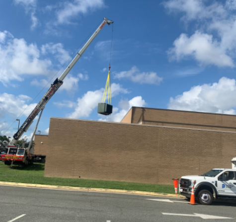A crane lifts the new transformer to install it in the building 