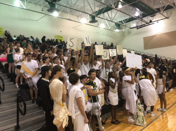 The senior class, wearing togas, hold signs and make as much noise as they can. 