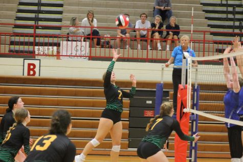 Senior captain Reagan Kruger goes up for a third Cavalier hit with two Deep Run blockers right against the net.