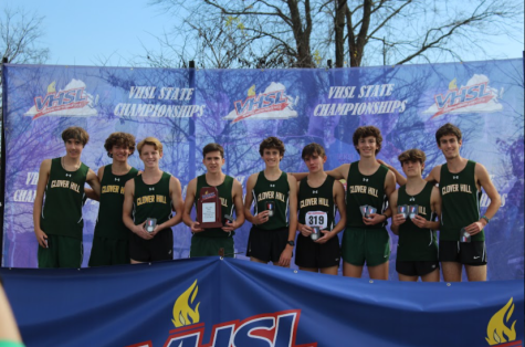 The cross country team stands on the podium at the awards ceremony holding their runner-up trophy.