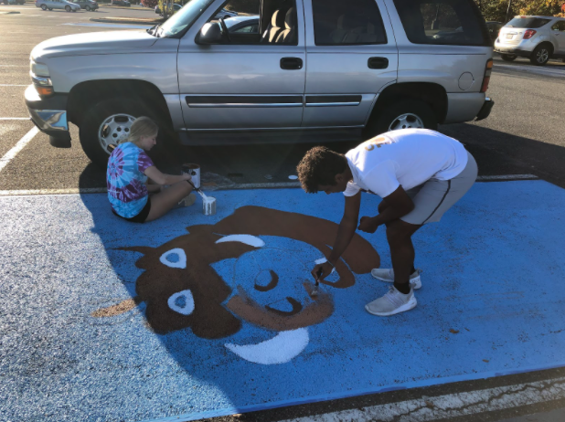 Katie Morton and Justin Escamilla paint Pumbaa from The Lion King