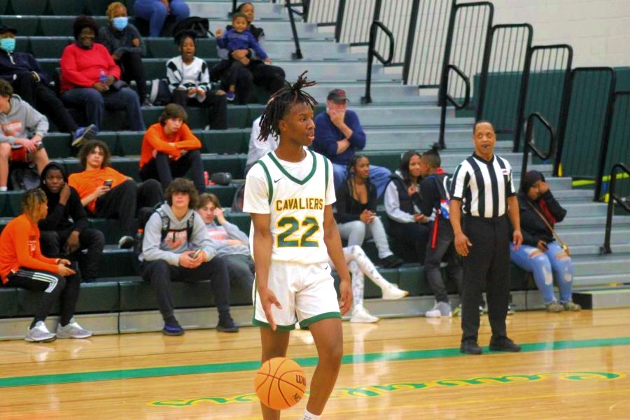 Junior Mikea Lewis dribbles the ball around the three-point arc.