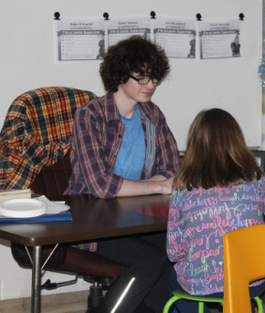 Carter Fischer helps students with their work while helping in a classroom at Swift Creek Elementary School.