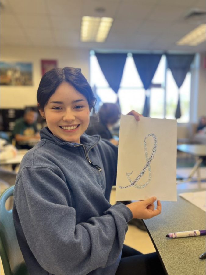 Sofia Mangini holding cursive artwork.