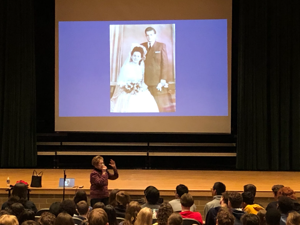 Halina Zimm speaks to students in the auditorium. The picture on the projector, which is part of a revolving slideshow, shows her on her wedding day after the war. 