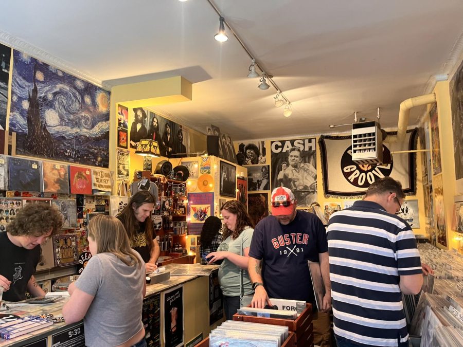 Shoppers inside Deep Groove flipping through crates of records