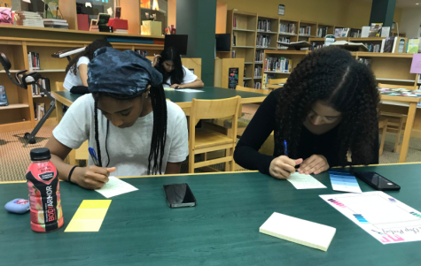 Juniors Vanessa Wigfall and Layla Vega work on paint chip poems during the second poetry workshop.