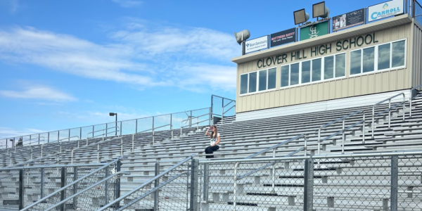 Junior Natalie Cutchins posing for a photo in the empty bleachers.