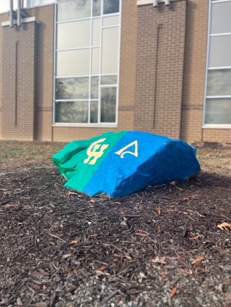 Dual painted rock in front of the school with the Math/Sci and Clover Hill emblem.