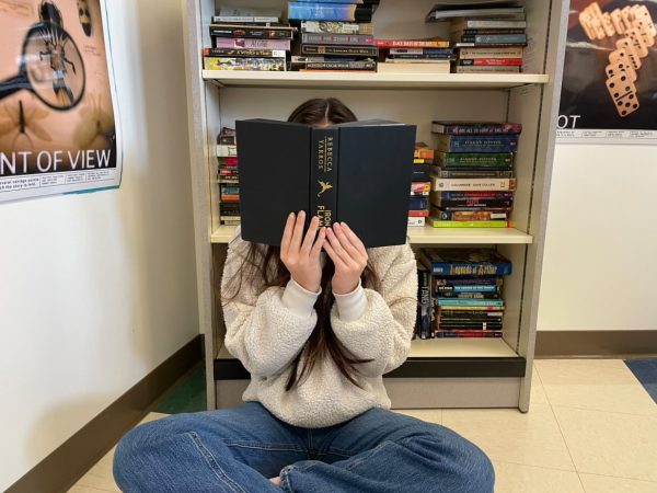 Sophomore Lily Schofield posing with a book