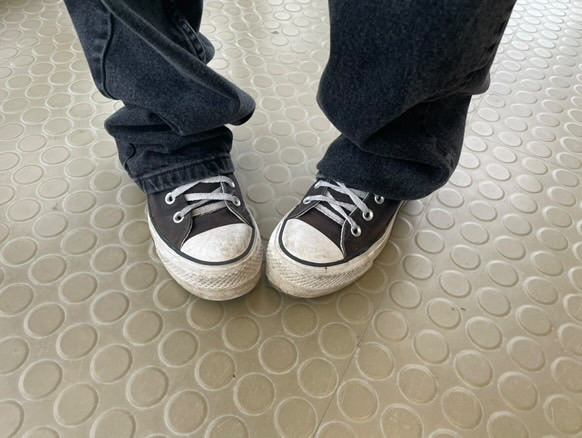 Close up picture of a student wearing black Converse shoes