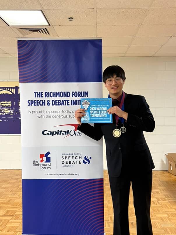 Matthew Wang holding an award for qualifying at the Speech and Debate Nationals