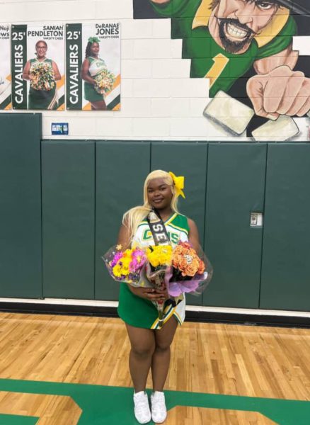 DeRanae Jones poses in her cheer uniform holding bouquets
