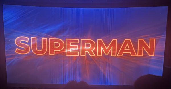 Title screen of Superman (2025) on an IMAX screen with "SUPERMAN" written in bright, bold, red letters against a dark blue background with streaks.