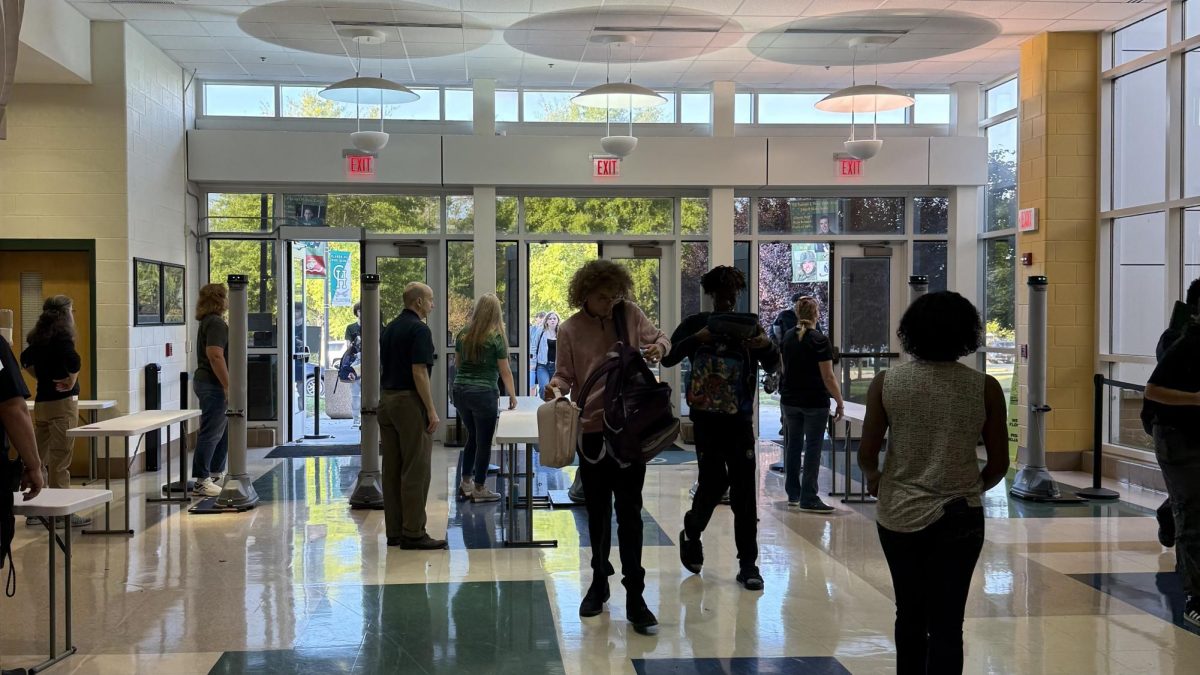 Students passing through the metal detectors in the morning as staff helps out.