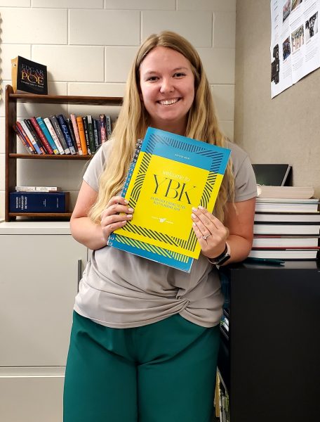Southworth holding a guide for yearbook advisors 