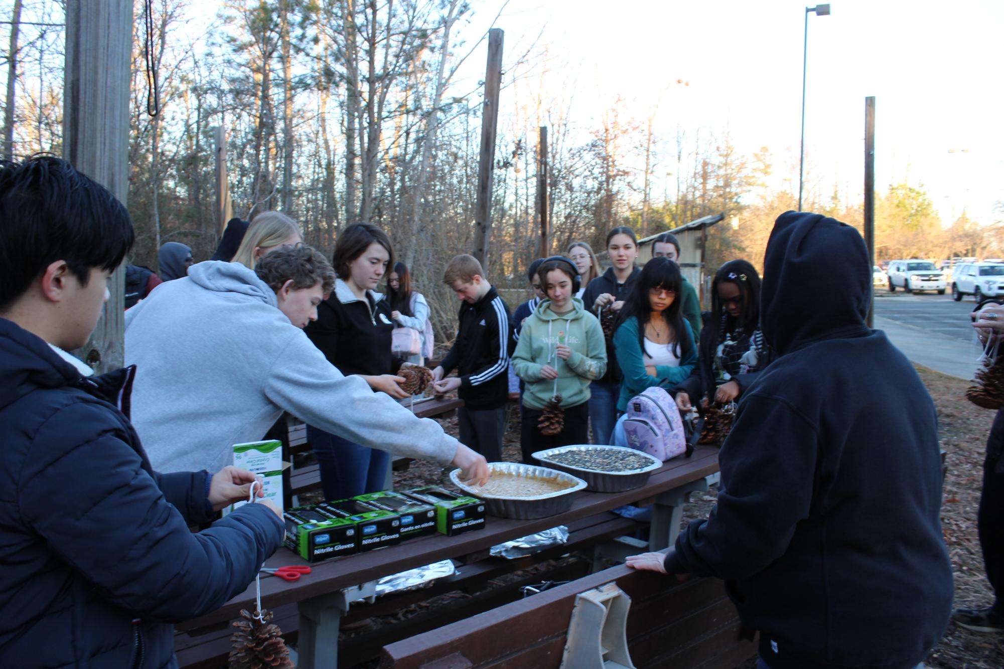 Freshman Biology Club students prepare to make bird feeders with a mixture of peanut butter, bacon fat, and cayenne pepper with seeds to coat the mixture.  